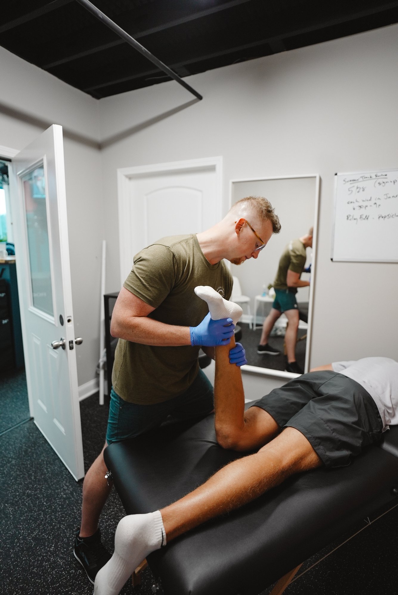 Physical therapist treating runner's knee injury with manual therapy at Peachtree City clinic Physical therapist treating runner's knee injury with manual therapy at Peachtree City clinic